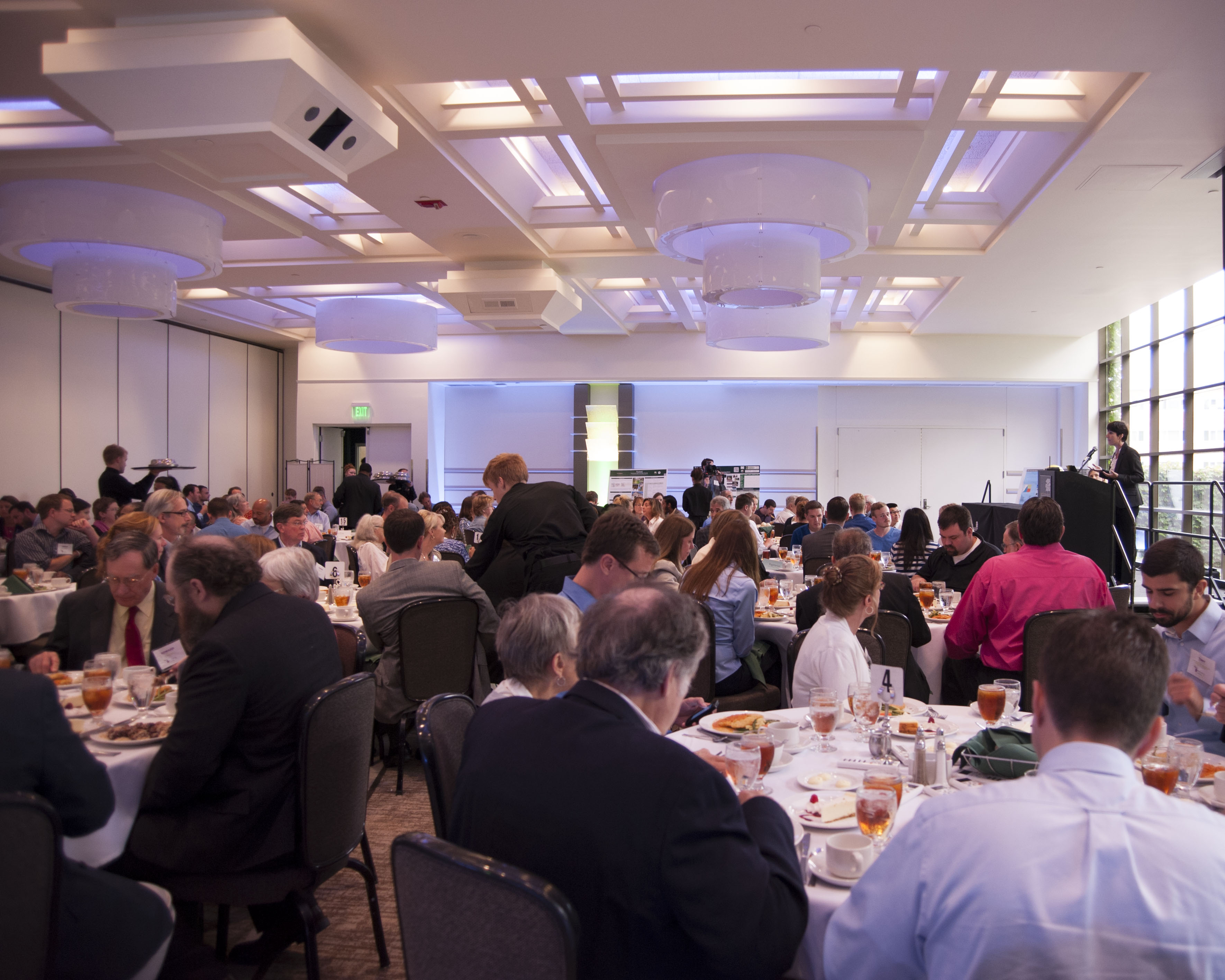 Photo of Innovate Michigan! Summit attendees listening to a presentation by keynote speaker, Ayleen Robainas Barcia.