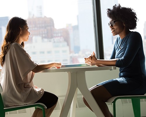 Two women talking at a table